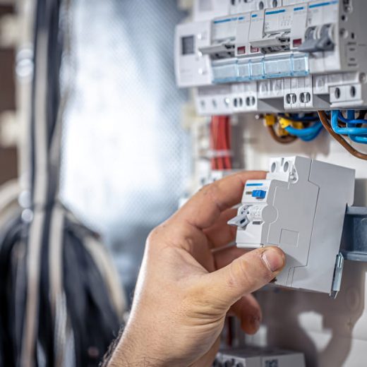 male-electrician-works-switchboard-with-electrical-connecting-cable